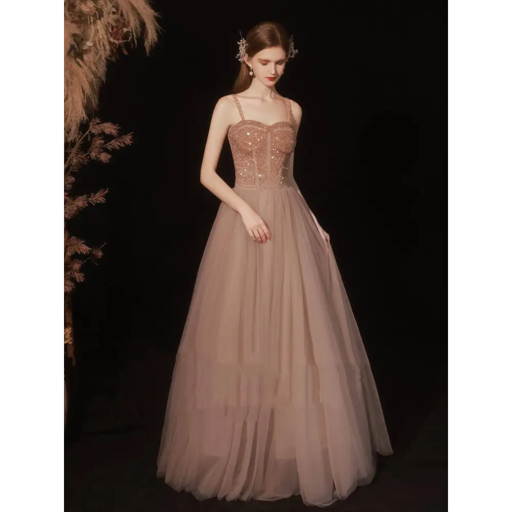 A rose gold sequin golden suspender dress female dinner featuring a shimmering bodice and flowing champagne tulle skirt
