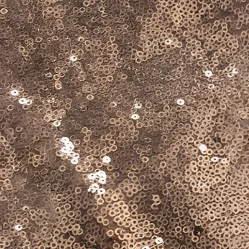 Rose gold sequined fabric with small circular embellishments on a large bridesmaid dress for banquet events