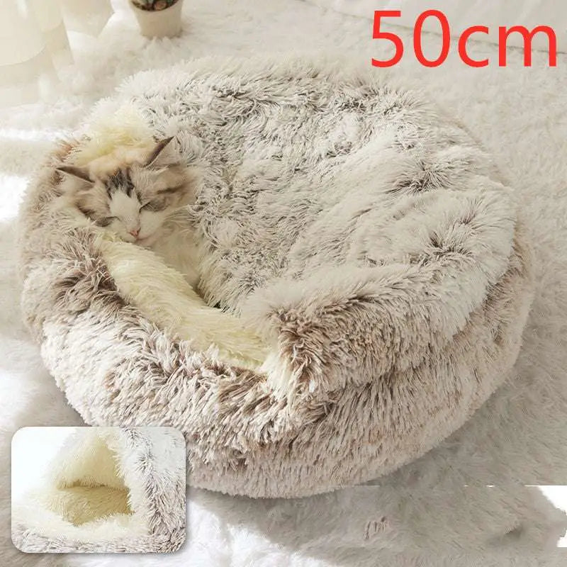 A cozy pink round plush cat bed pet with gray and white faux fur exterior and a soft cream inner lining
