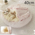A pink round plush cat bed pet made of soft white and pink faux fur with a cozy interior lining