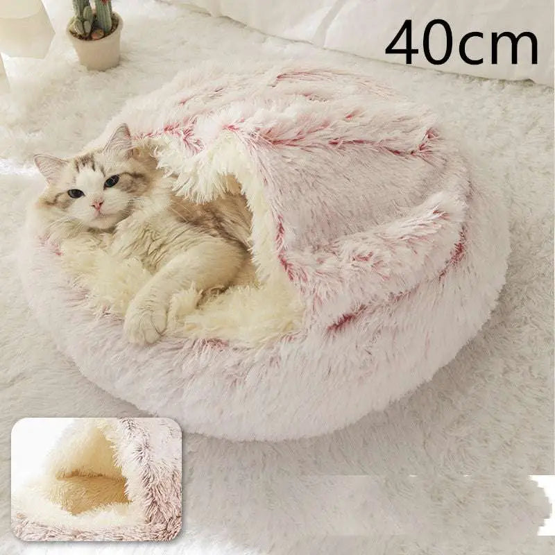 A pink round plush cat bed pet made of soft white and pink faux fur with a cozy interior lining