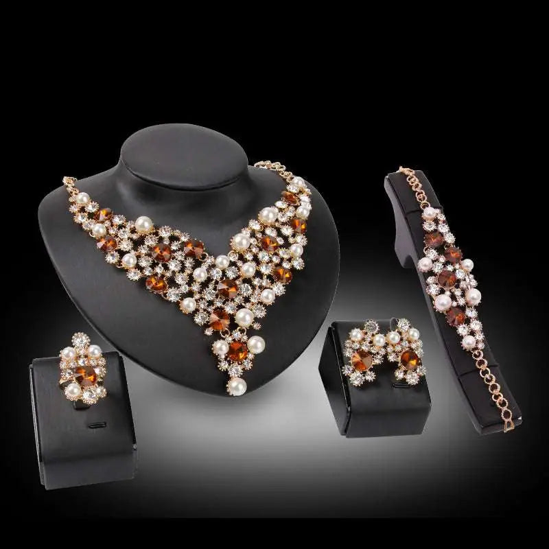 Gold-toned bridal clothing accessories necklace earrings with amber and white pearls for royal blue bridal wear displayed on busts