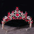 A sparkling red and gold rhinestone mitzvah crown featuring intricate leaf motifs clear crystals and a central ruby gemstone