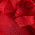 A vibrant red satin ribbon bow with woven texture on a royal blue headdress bride beige hat imitation linen