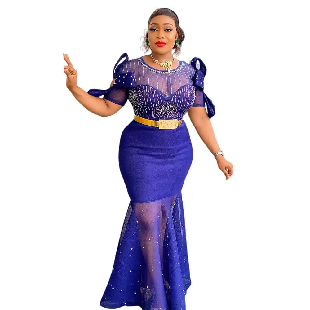 A woman wears a royal blue heavy embroidered hot diamond beads gown with sheer beaded bodice and mermaid skirt