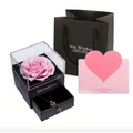 Pink preserved rose in a clear acrylic display box with black base and drawer for royal blue preserved rose jewelry gift