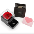 A vibrant red preserved rose in a clear acrylic box with black base for royal blue preserved rose jewelry gift