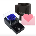 A royal blue preserved rose jewelry gift box featuring a vibrant rose in a clear acrylic display with black base and lid