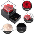 A vibrant red preserved rose in a clear acrylic box with black base and drawer in a royal blue preserved rose jewelry gift box
