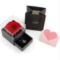 A vibrant red preserved rose jewelry displayed in a clear acrylic box with a black base for royal blue preserved gift