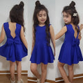 Back view of a royal blue summer girls sleeveless princess dress with a flared skirt and bow detail