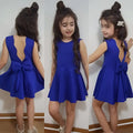 Back view of a royal blue summer girls sleeveless princess dress with a flared skirt and bow detail