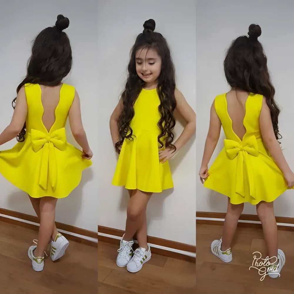 Back view of bright yellow sleeveless princess dress with a bow and flared skirt for royal blue summer wear