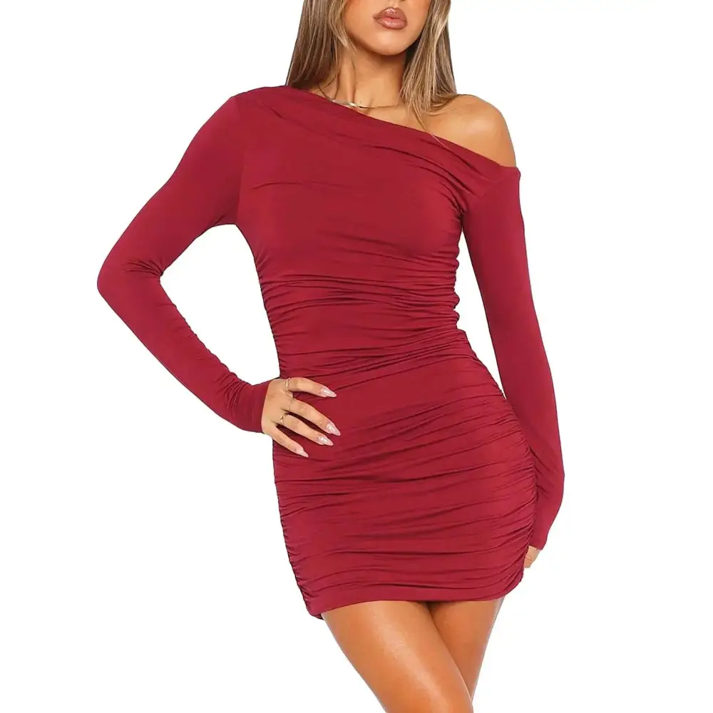A form-fitting wine red long sleeve dress featuring one shoulder design and ruched detailing in a mini length