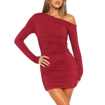 A form-fitting wine red long sleeve dress featuring one shoulder design and ruched detailing in a mini length