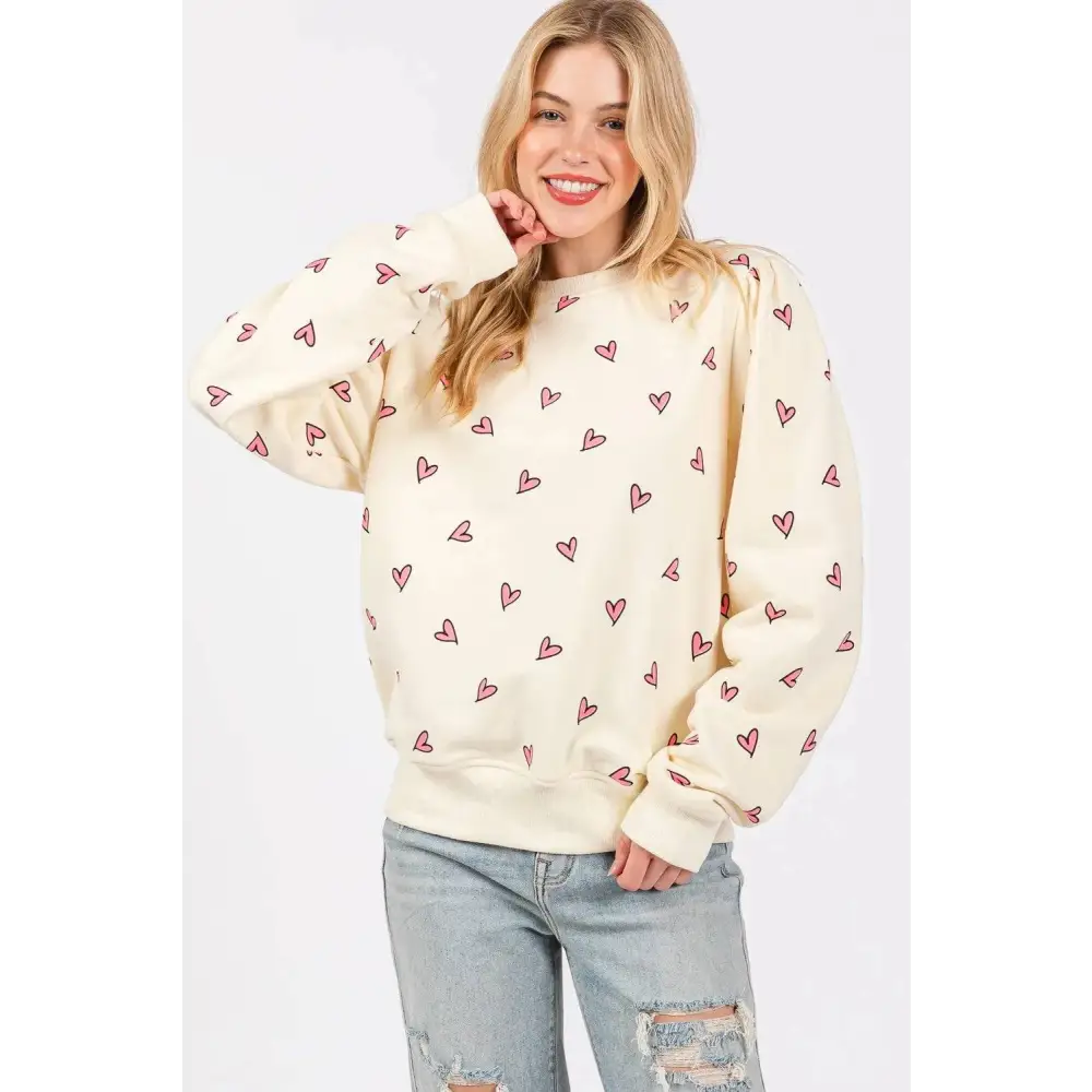 Cream-colored sage fig long sleeve sweatshirt with fig heart printed pattern of small pink hearts scattered across fabric
