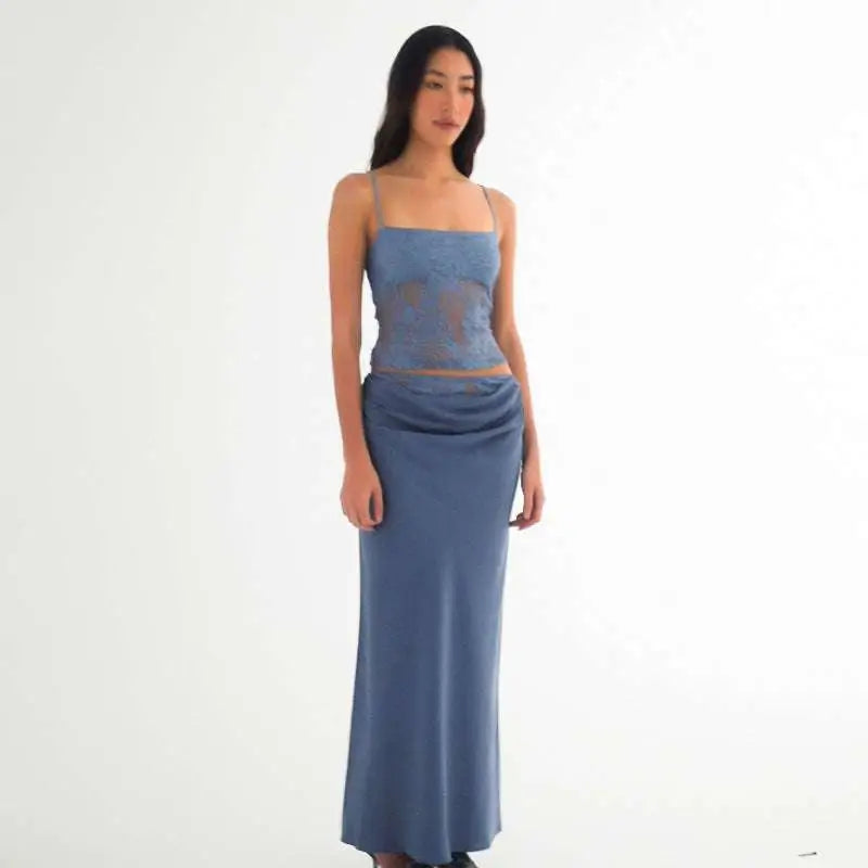 A woman wears a sage green lace backless tube with stitching ruffle hip and a matching flowing skirt in sheer lace