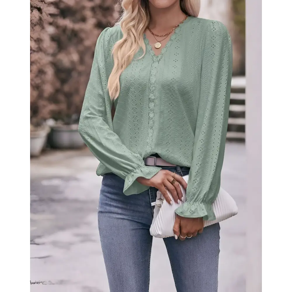 A light green blouse with lace sleeves fashionable design featuring eyelet pattern and ruffled cuffs, versatile shirt