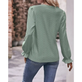 A sage green lace blouse with delicate eyelet lace sleeves and puffed detailing, a fashionable versatile shirt