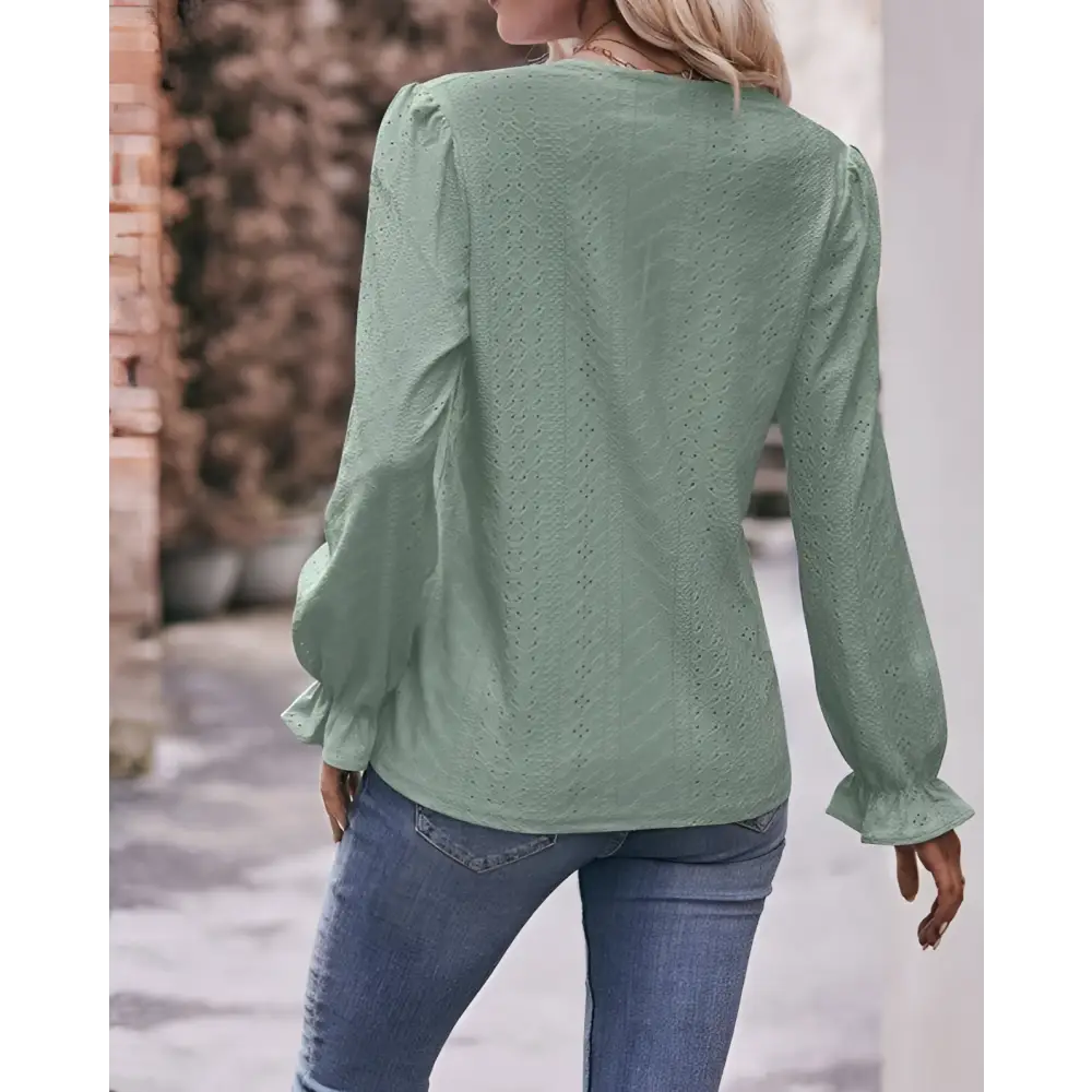 A sage green lace blouse with delicate eyelet lace sleeves and puffed detailing, a fashionable versatile shirt