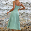 A mint green satin slit sling sleeveless midi dress with thin straps and fitted silhouette for sling dress summer wear