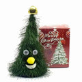 A green fuzzy christmas tree figurine with googly eyes and gold bell featured in claus climbing rainbow parachute toy