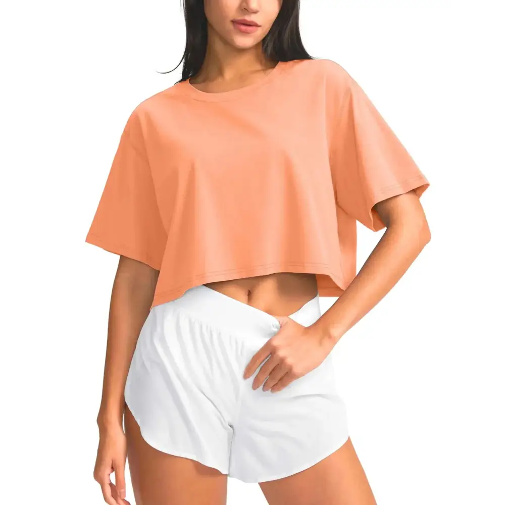 Cropped peach-colored santiny cotton crop workout top with relaxed fit and short sleeves for comfortable exercise