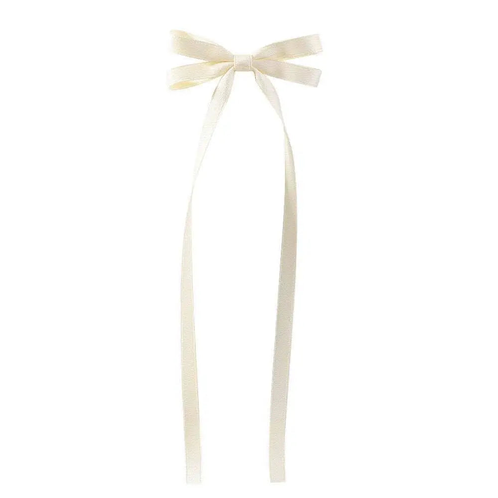 Cream-colored satin bow braided hair ribbon tie set with long flowing tails made from smooth satin material