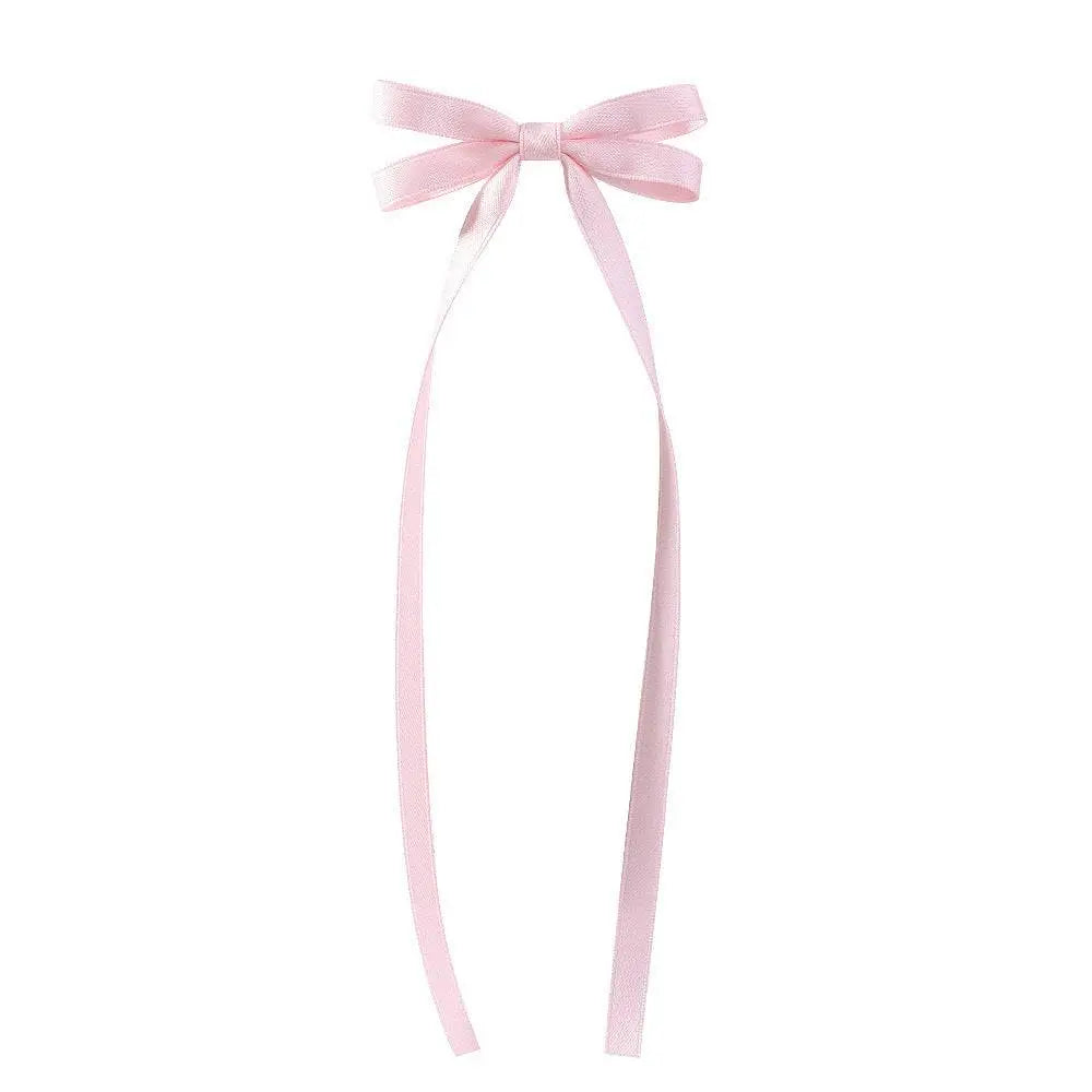 A delicate pink satin bow braided hair ribbon tie set with long flowing tails for elegant hair styling use