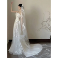 A flowing white satin lace wedding veil with delicate floral embroidery paired with a fishtail dress