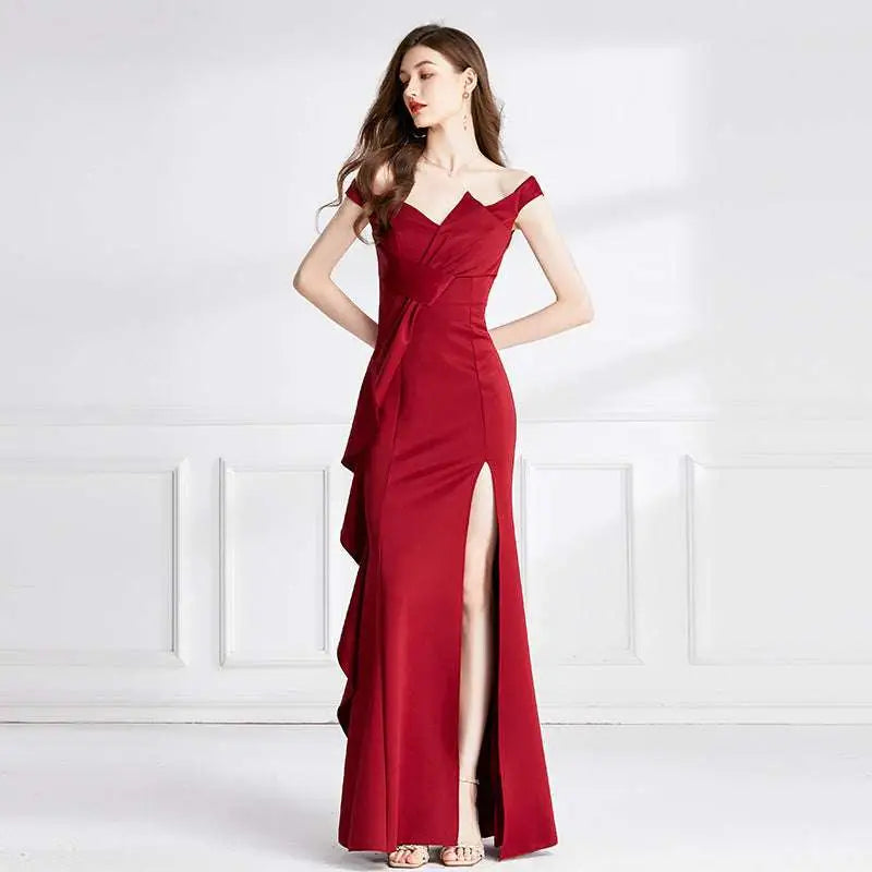 A sleek deep red satin evening dress with an off-the-shoulder neckline and a flattering high slit