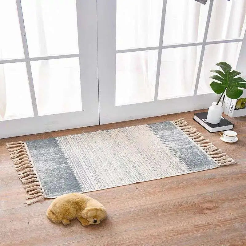 A rectangular scandinavian style linen cotton rug with a gray and cream geometric pattern and tassels on edges