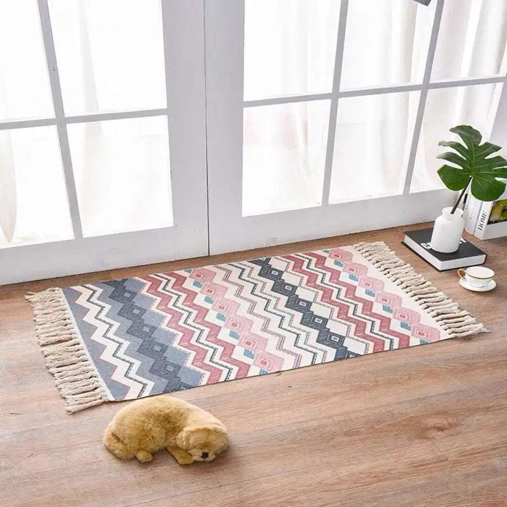Scandinavian style linen cotton rug with a pink gray and white geometric pattern and fringed tassel edges