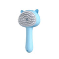 Light blue cat-shaped self-cleaning mist cat and dog grooming brush with soft white bristles and plastic handle