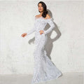 A shimmering white long sleeve mermaid-style gown with feathered shoulder accents for formal events