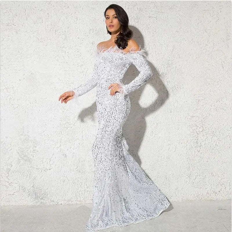 A shimmering white long sleeve mermaid-style gown with feathered shoulder accents for formal events
