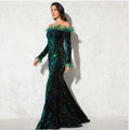A shimmering emerald and black sequined off-the-shoulder fishtail gown with burgundy feather shoulder accents