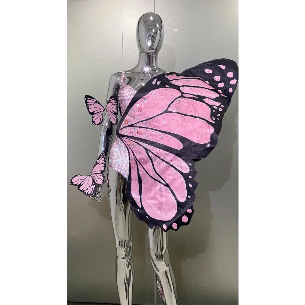 Sequin butterfly latin dance skirt dress with pink and black sequined wings and pink polka dots on silver mannequin