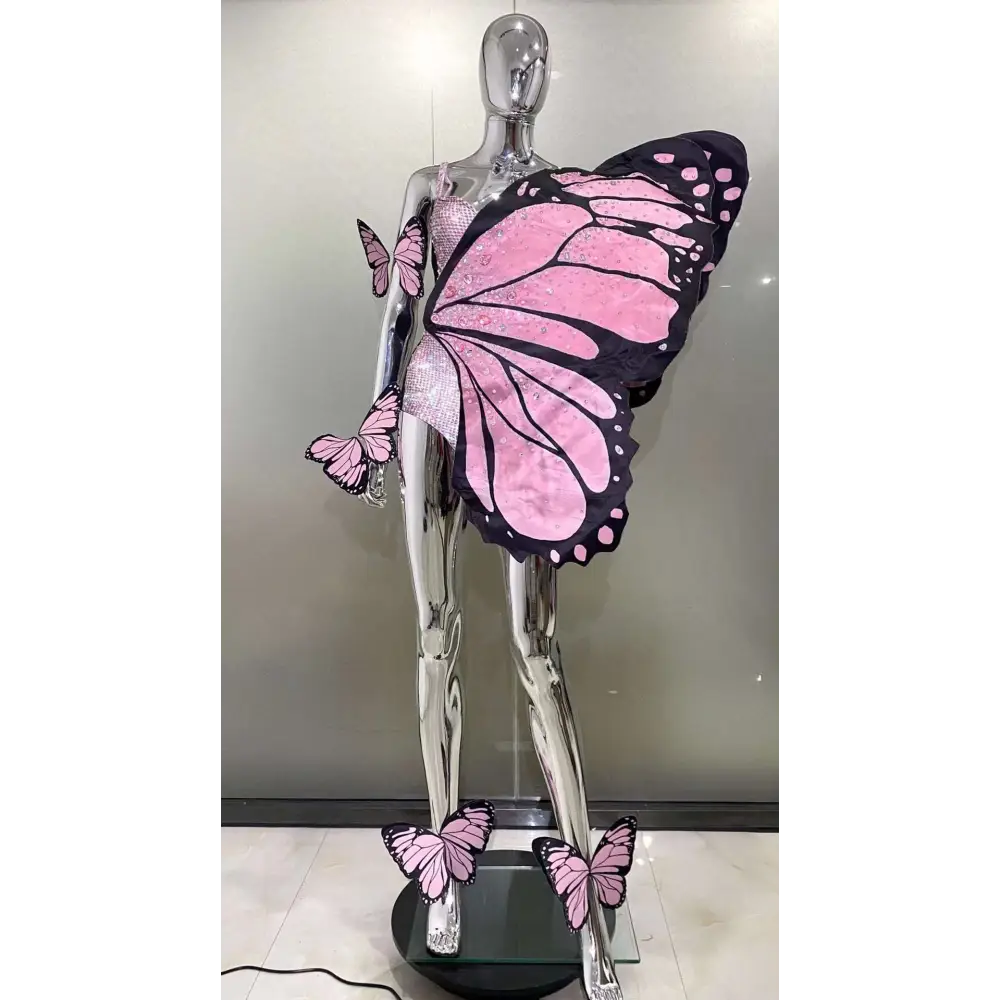 Chrome mannequin adorned with pink and black sequin butterfly latin dance skirt dress featuring glittery texture wings