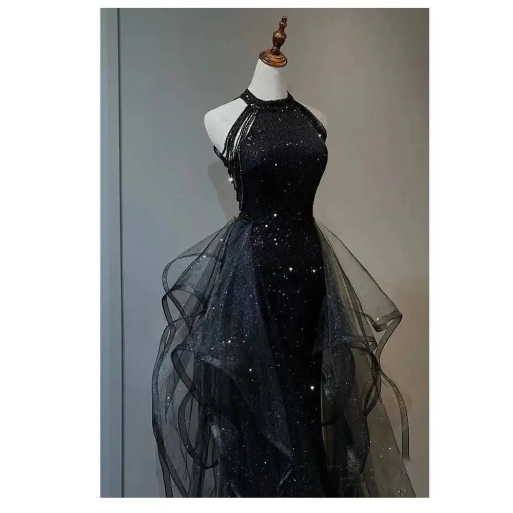 Black sequined halter neck evening dress with layered sheer tulle overlay and flowing tulle skirt for formal events
