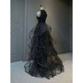 Black evening dress featuring a sequined halter neck and layered sheer tulle skirt for elegant occasions