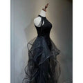Black sequined halter neck evening dress with layered sheer tulle skirt and cascading beaded straps