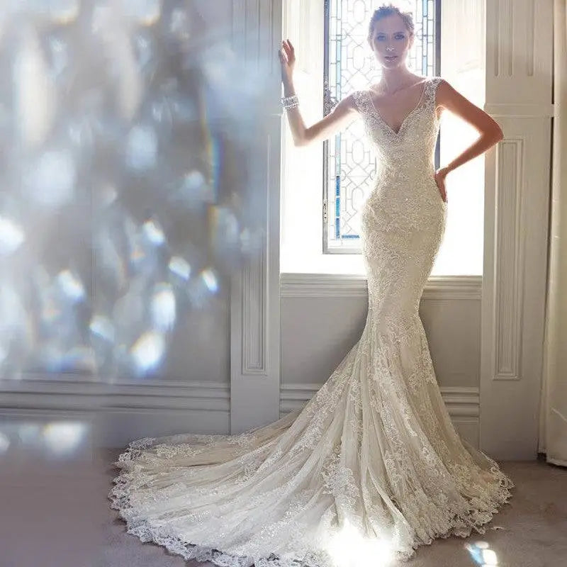 A stunning ivory lace mermaid wedding dress with intricate beading and lace detailing perfect for brigade shooting seaside
