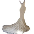 Ivory mermaid wedding dress with intricate lace detailing and a shimmering flowing train for brigade shooting seaside