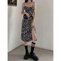 Black and white leopard print satin slip dress with thin spaghetti straps and side slit featuring leopard print chain detail