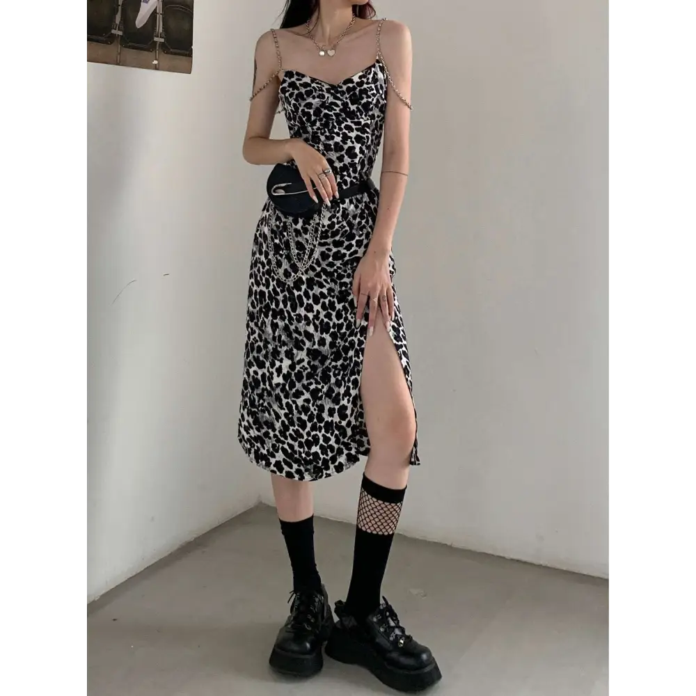 Black and white leopard print satin slip dress with thin spaghetti straps and side slit featuring leopard print chain detail