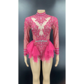 A vibrant fuchsia shiny rhinestone mesh performance leotard with long sleeves and a layered tulle skirt