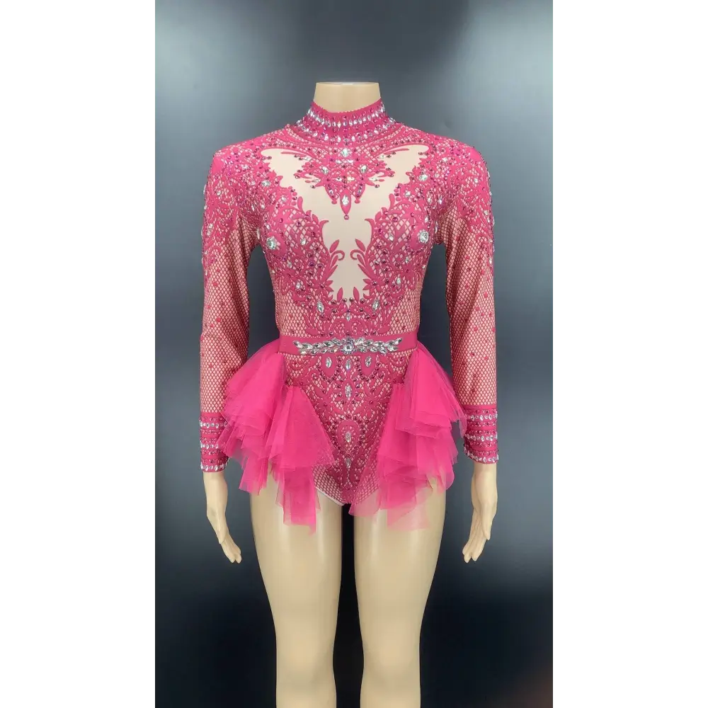 A vibrant fuchsia shiny rhinestone mesh performance leotard with long sleeves and a layered tulle skirt