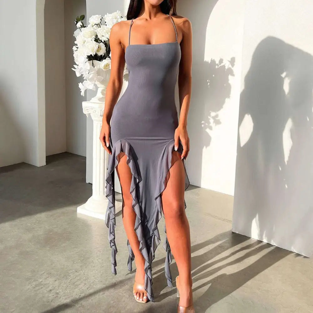 A sleek gray sexy suspender tight dress with slim skirt design, high slit, and layered ruffle detailing along the hem