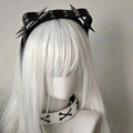 Black sharp claw kitty leather rivet headband with silver spikes and eyelets worn over white synthetic hair